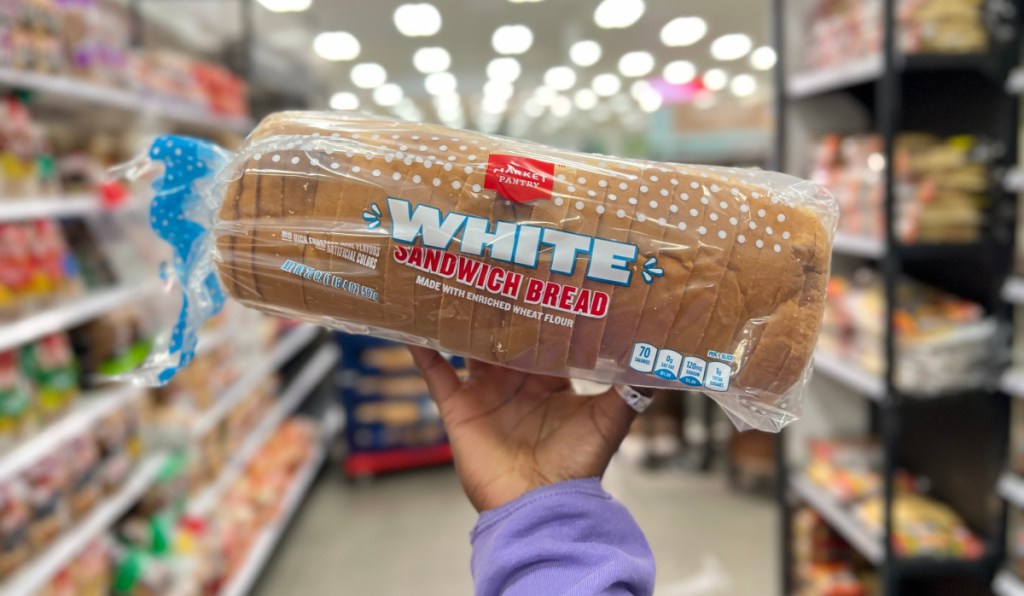 Hand holding up white bread, one of the foods to avoid on keto