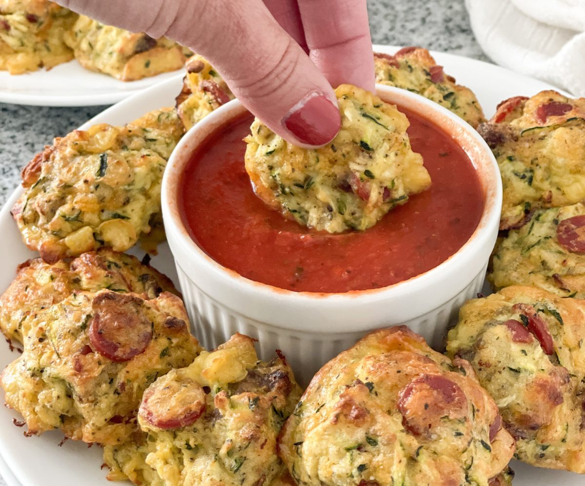 dipping zucchini pizza bites in marinara