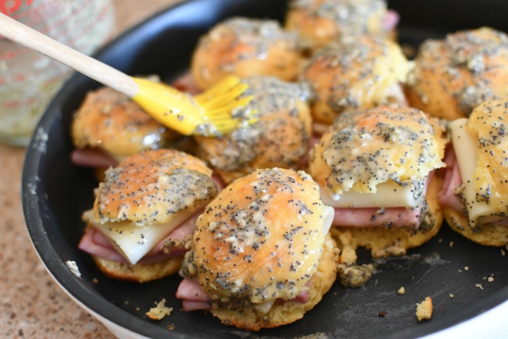 brushing butter mustard on keto ham and cheese sliders