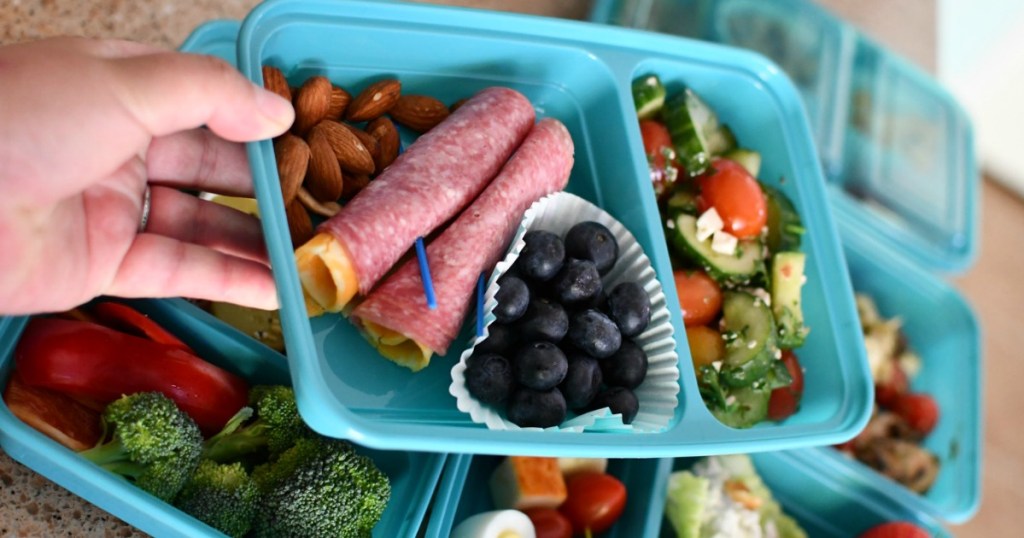 holding meal prep container filled with keto foods