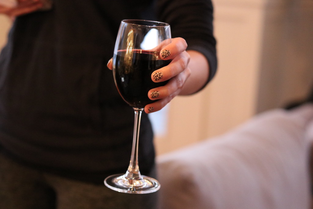 woman holding wine glass with leopard print nails 