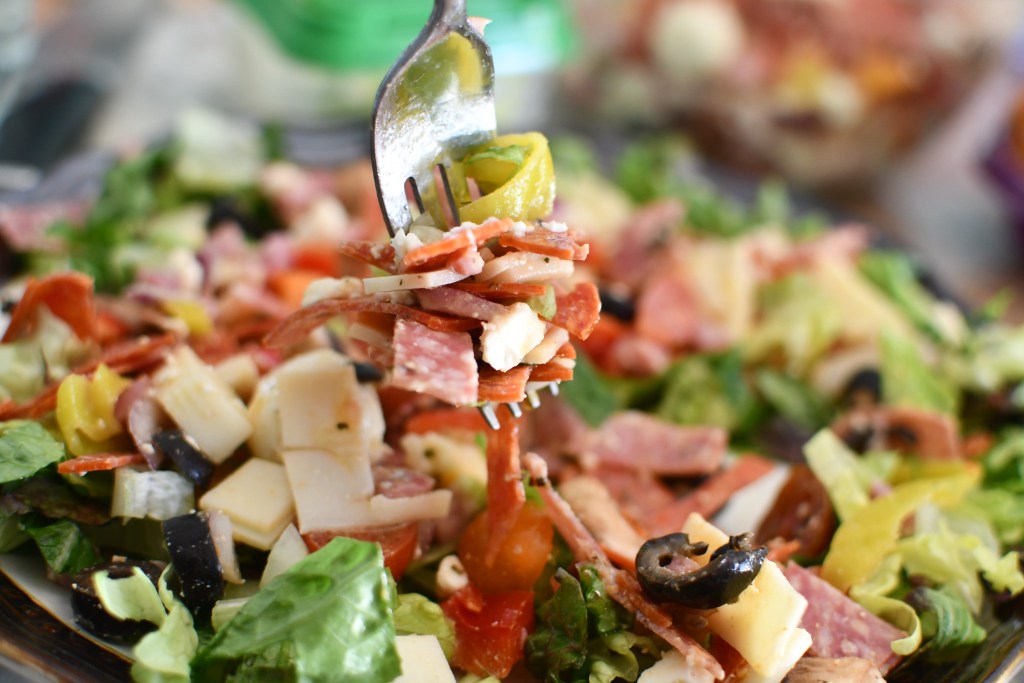 keto pizza salad with fork taking bite 