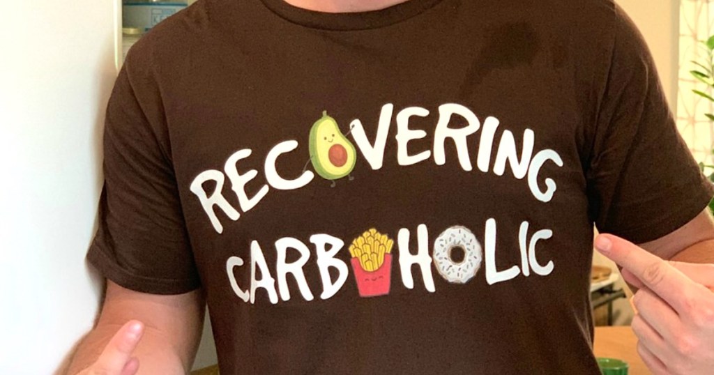 man pointing at tee he's wearing with the text recovering carboholic