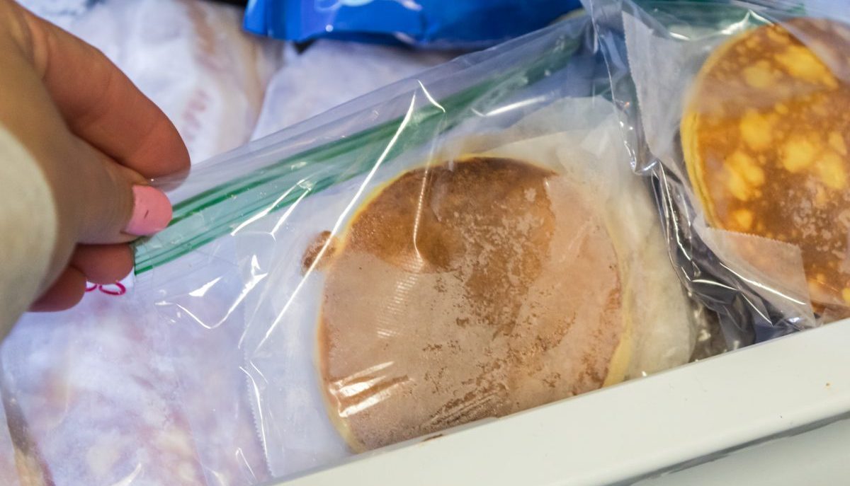 woman pulling pancakes out of the freezer