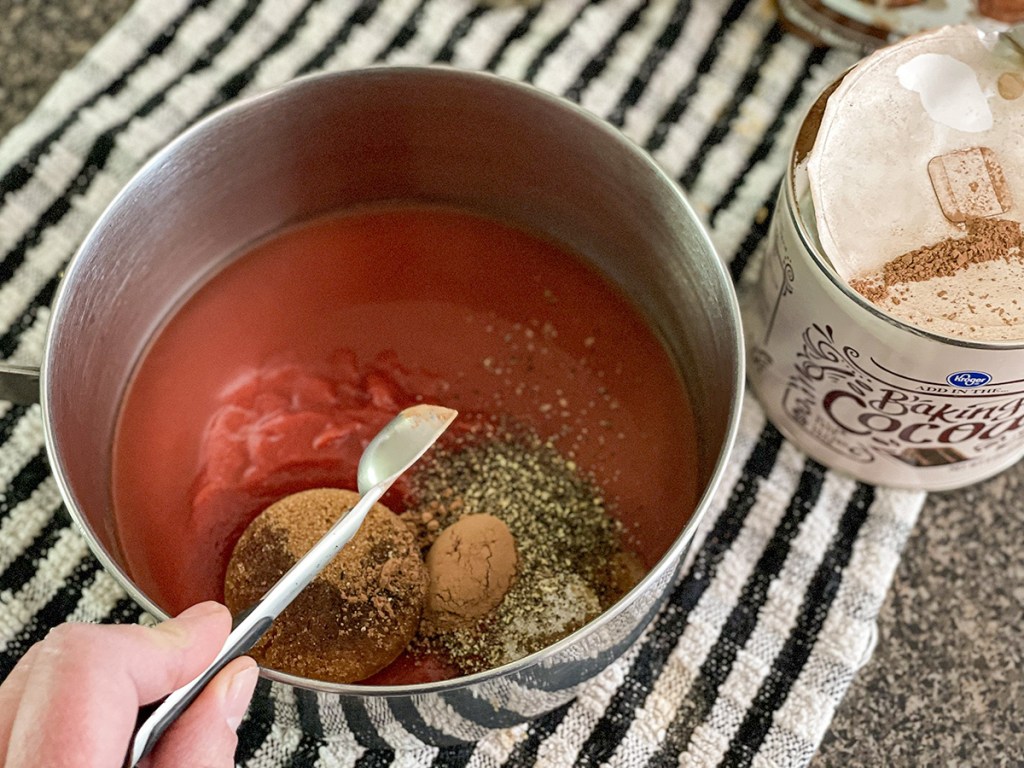 adding cocoa powder to a sauce pan