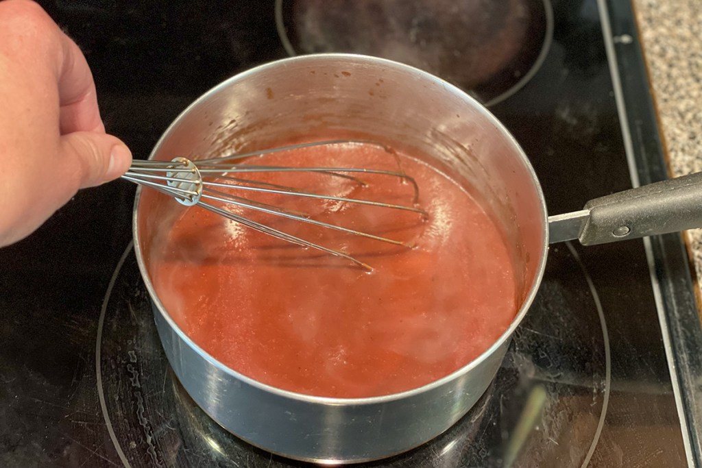 whisking keto bbq sauce on the stovetop