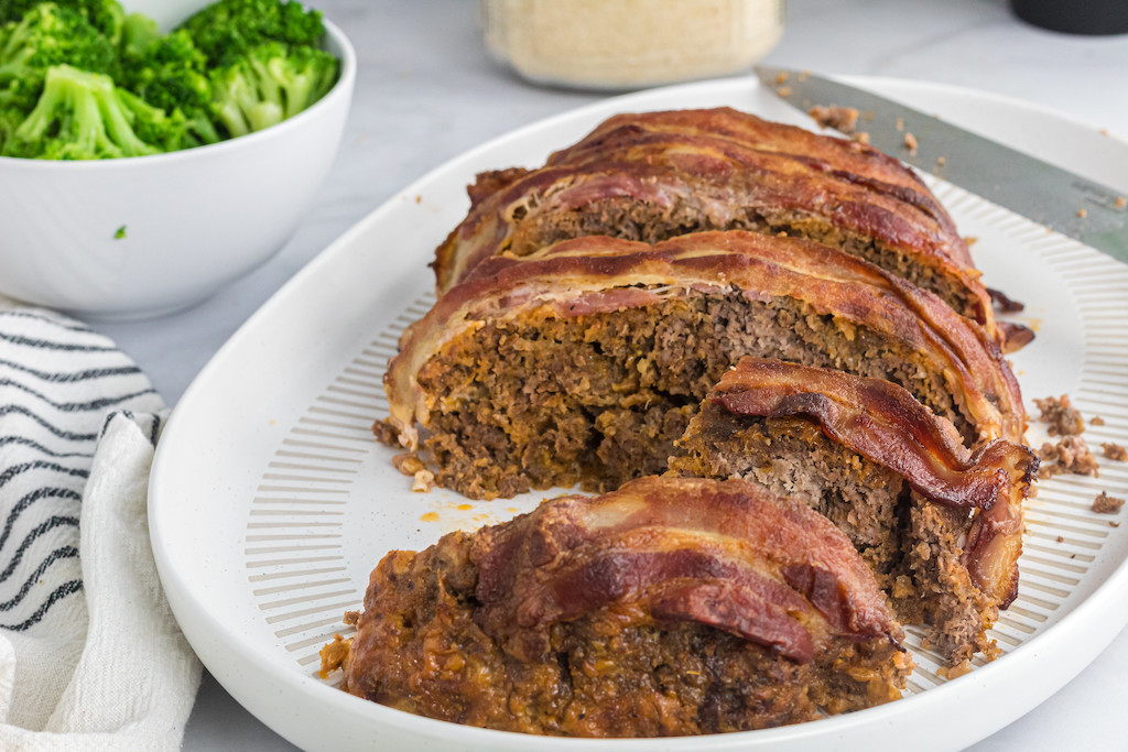 keto meatloaf sliced up on plate with broccoli on the side 