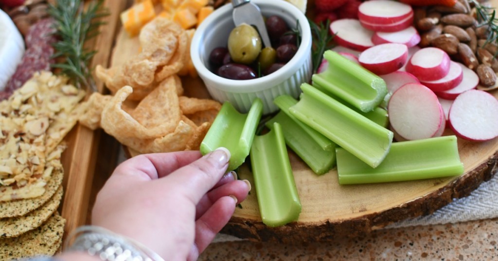 adding celery and radishes to charcuterie