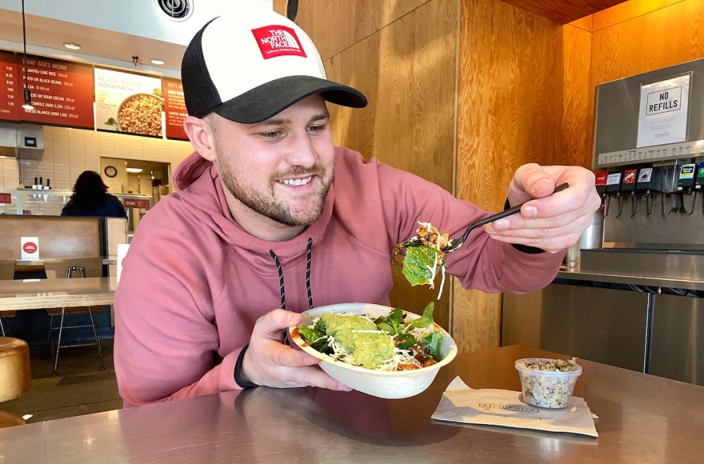 man holding fork looking at scoop of cauliflower rice