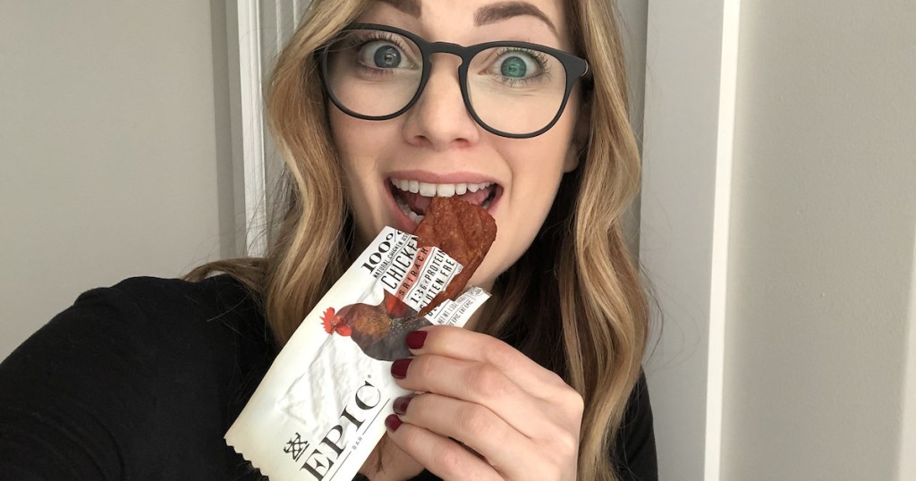 woman eating epic protein bar wearing glasses
