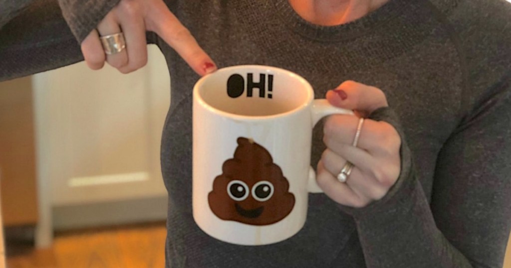 holding coffee mug that says 'oh poop'