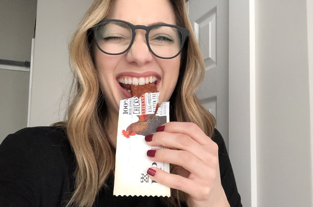 woman eating an epic chicken protein bar making weird face