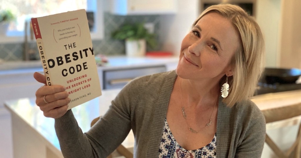 woman holding The Obesity Code book 