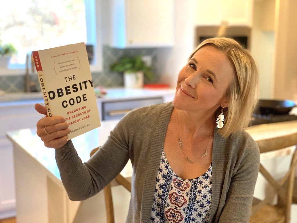 woman holding The Obesity Code book 