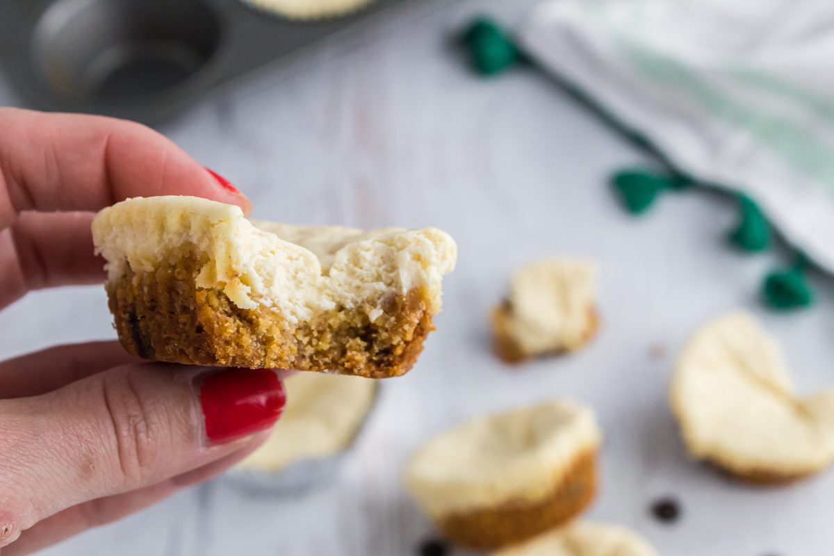 holding mini cheesecake with a bite out of it