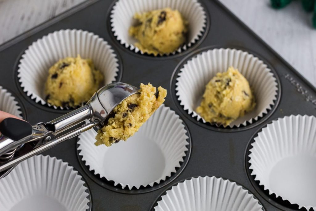scooping cookie dough into muffin tin