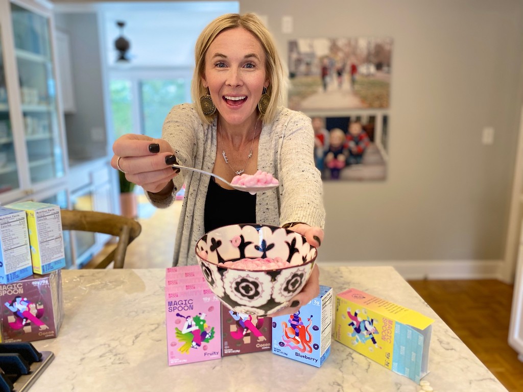 Woman holding spoon with Magic Spoon keto cereal on it