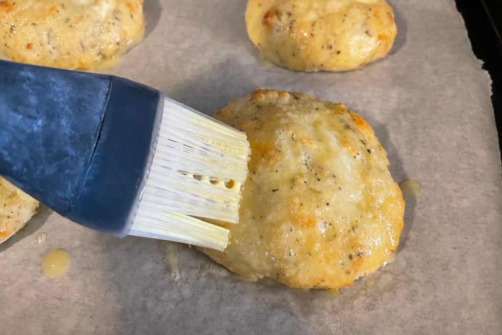 brushing egg wash on the buns