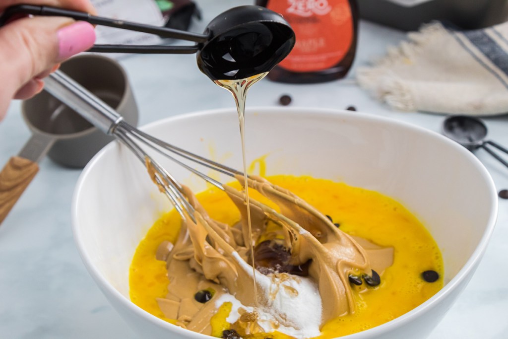 pouring in maple syrup to ingredients bowl