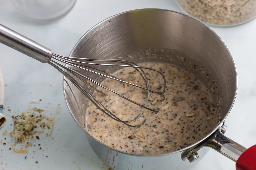 keto oatmeal in pan with almond milk and whisk 