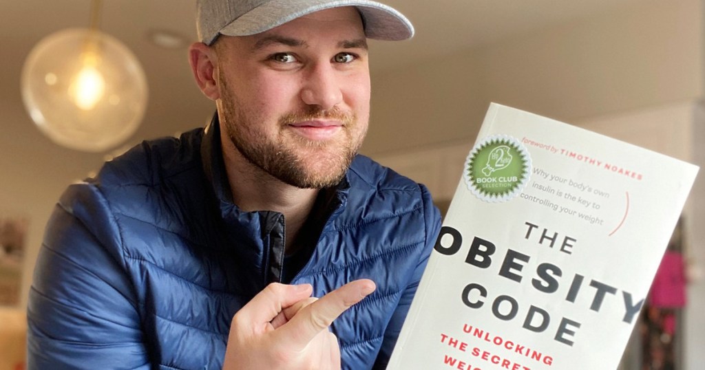 man holding obesity code book