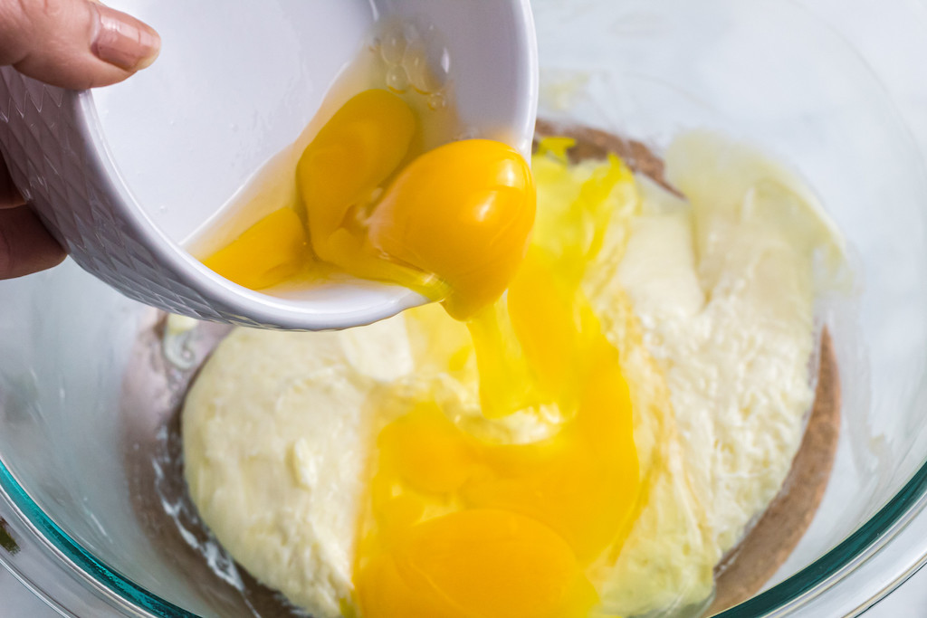 pouring eggs into bowl with other ingredients 