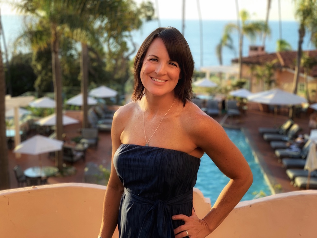 woman wearing blue dress in the tropics with hand on her hip