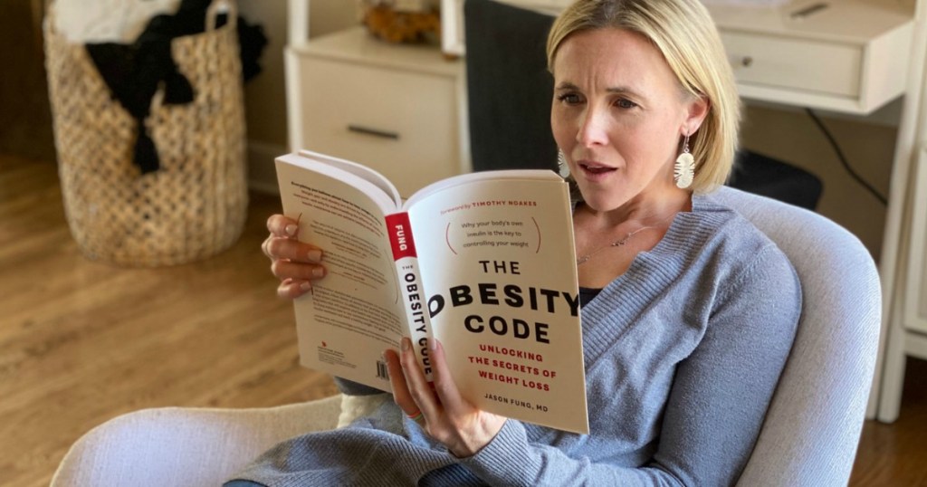 woman reading the obesity code keto book