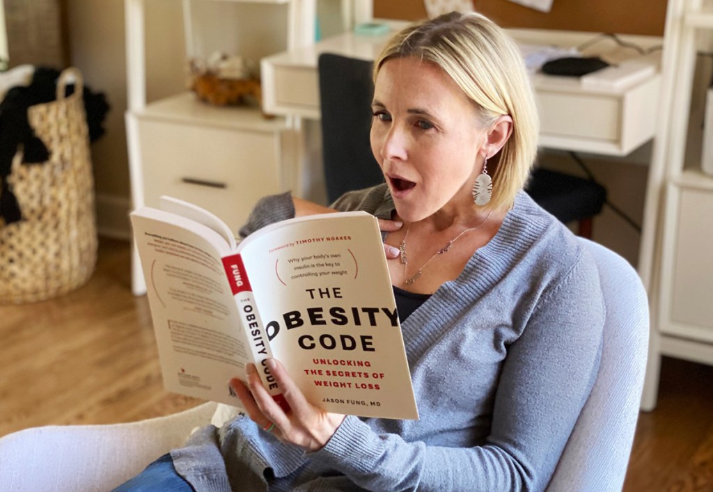 woman reading obesity code book