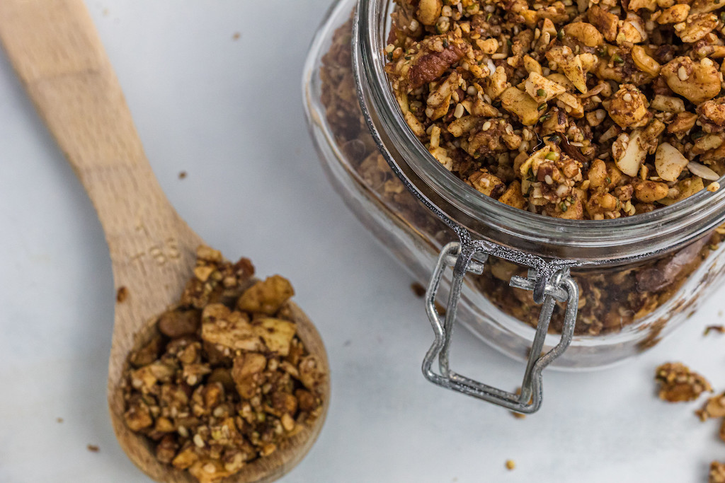 keto granola in canister with measuring spoon