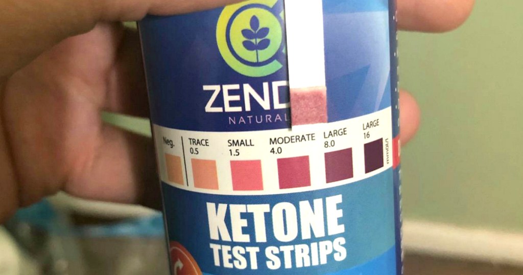 person holding ketone test strips