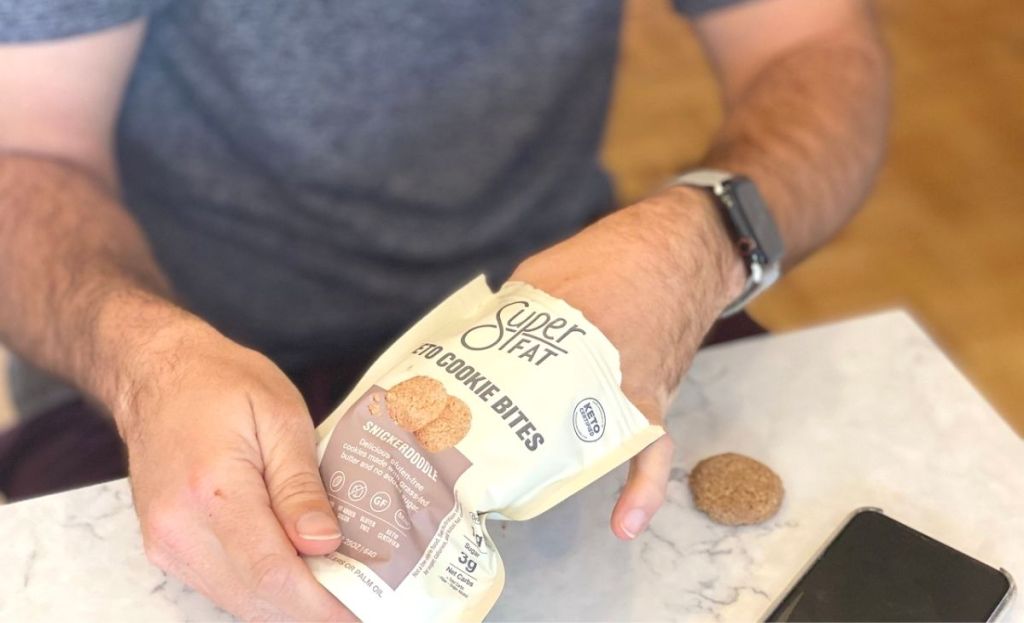 A man grabbing some superfat keto cookies out of a bag