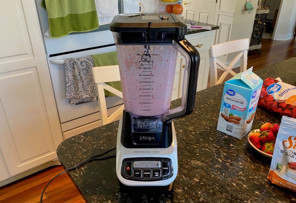 blender with milkshake ingredients mixing inside