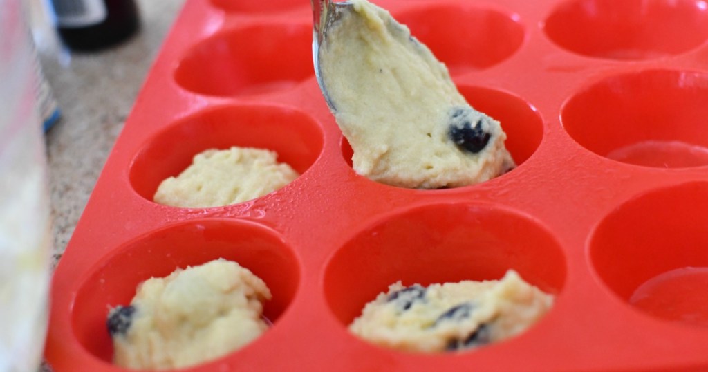 filling silicone molds with keto blueberry muffin batter