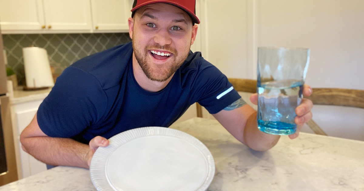 man holding empty plate and water
