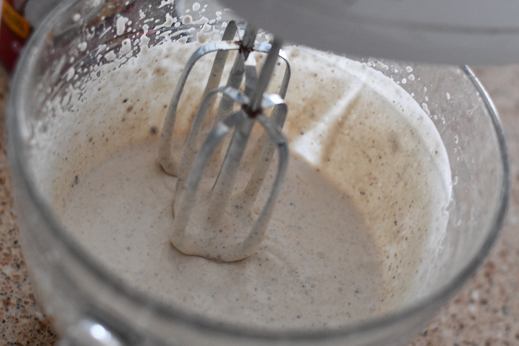 using hand mixer in bowl to mix liquid ingredients 