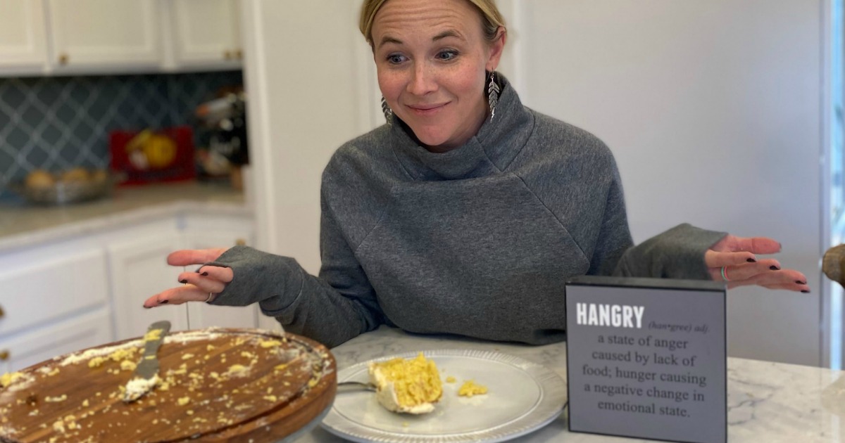 woman with hands out and empty cake platter in front of her with hangry sign