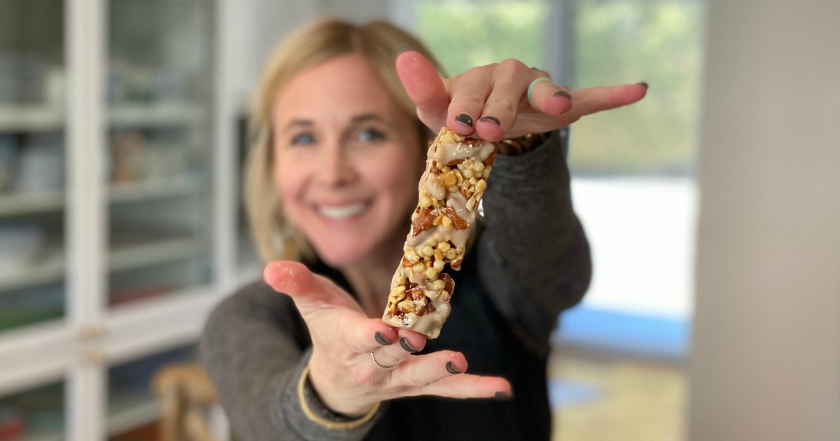 woman holding out Quest Nutrition snack bar 