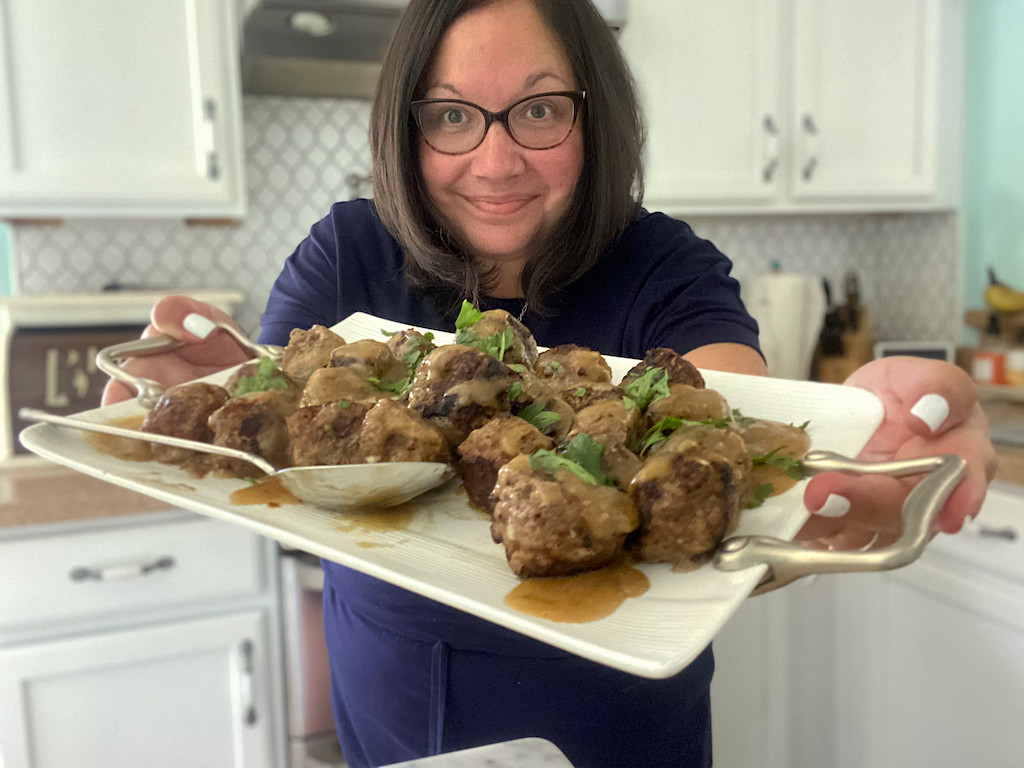 woman holding tray of Swedish meatballs