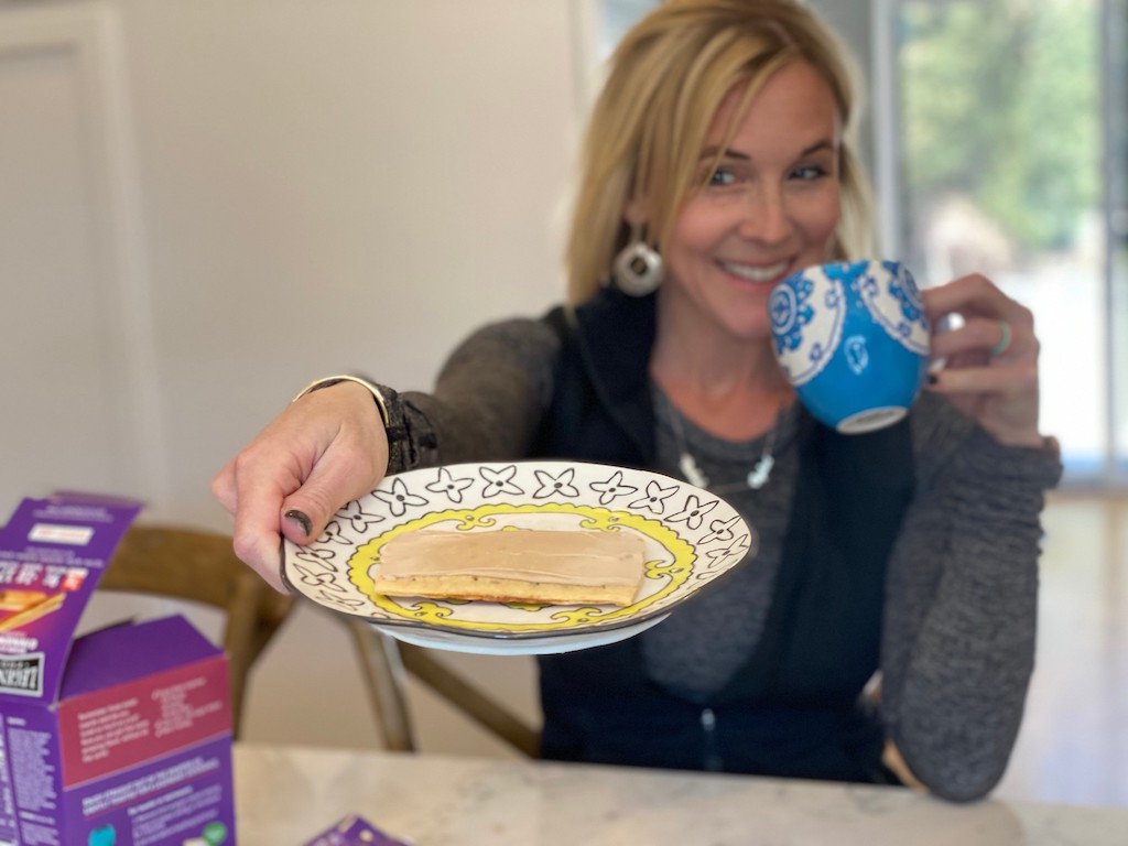 woman holding out keto toaster pastry and coffee mug