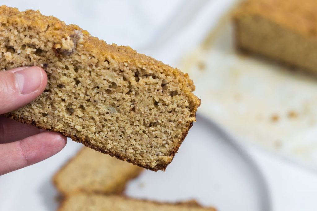 girl holding slice of keto banana bread