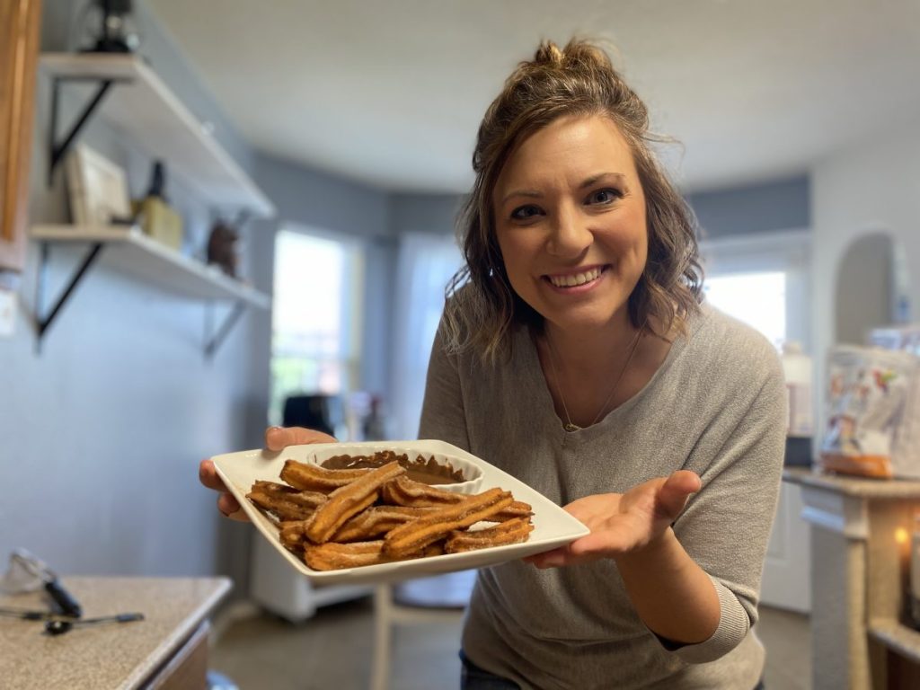 girl holding plate of keto churros