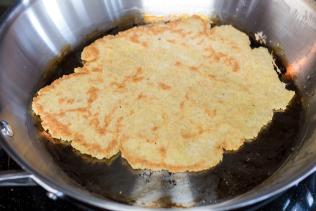 keto Naan bread in a skillet frying 