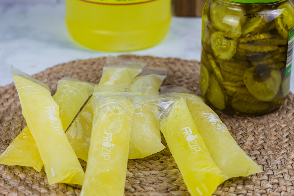 pickle juice pops on counter next to jar of pickles 