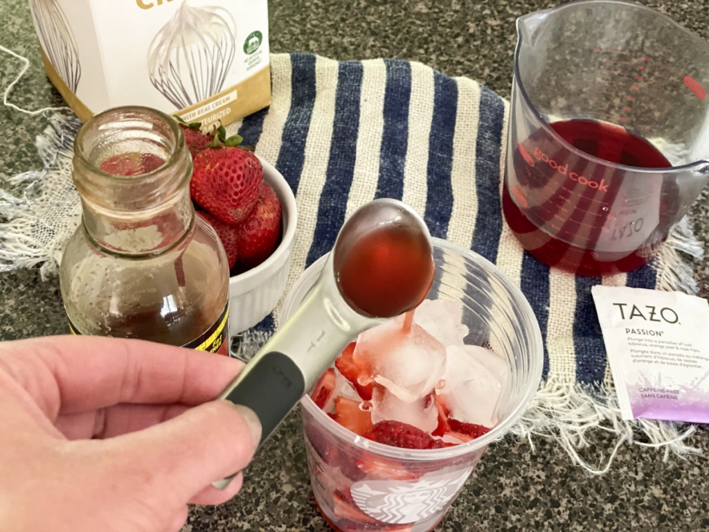 adding sugar-free strawberry syrup to a glass