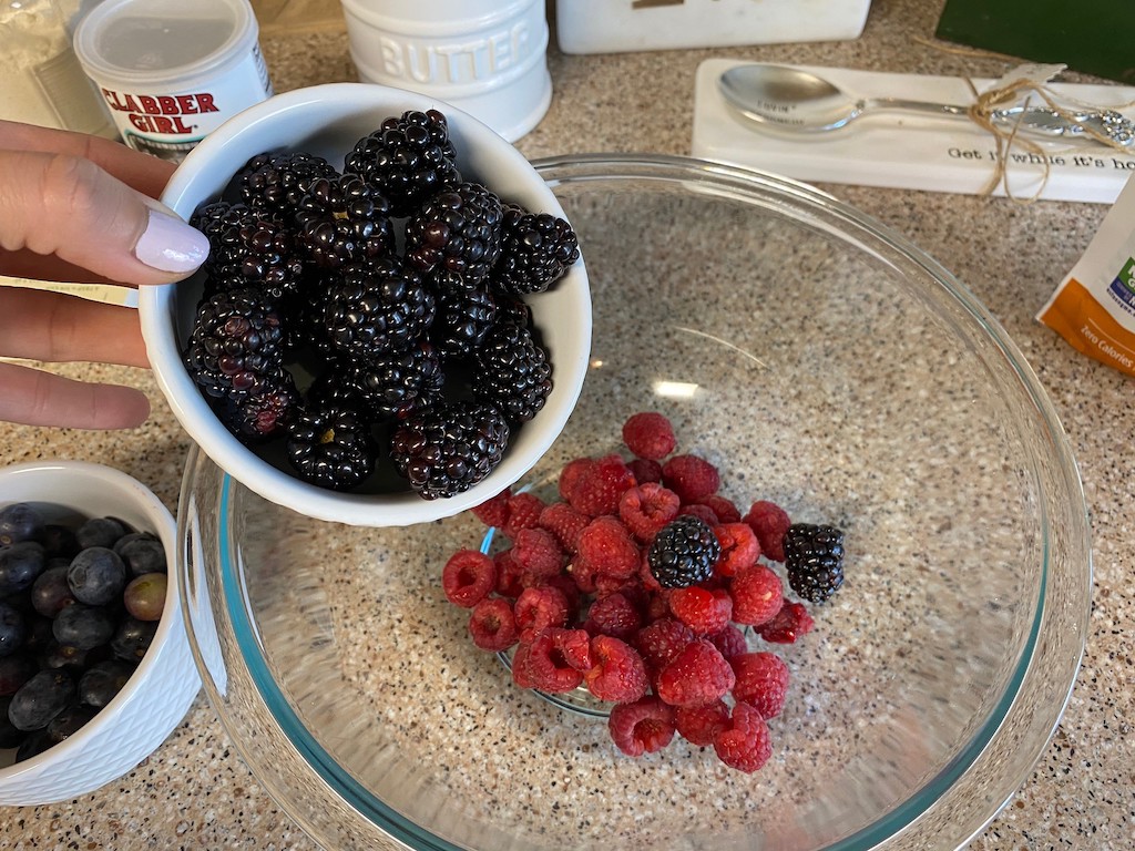 putting fresh berries in bowl 