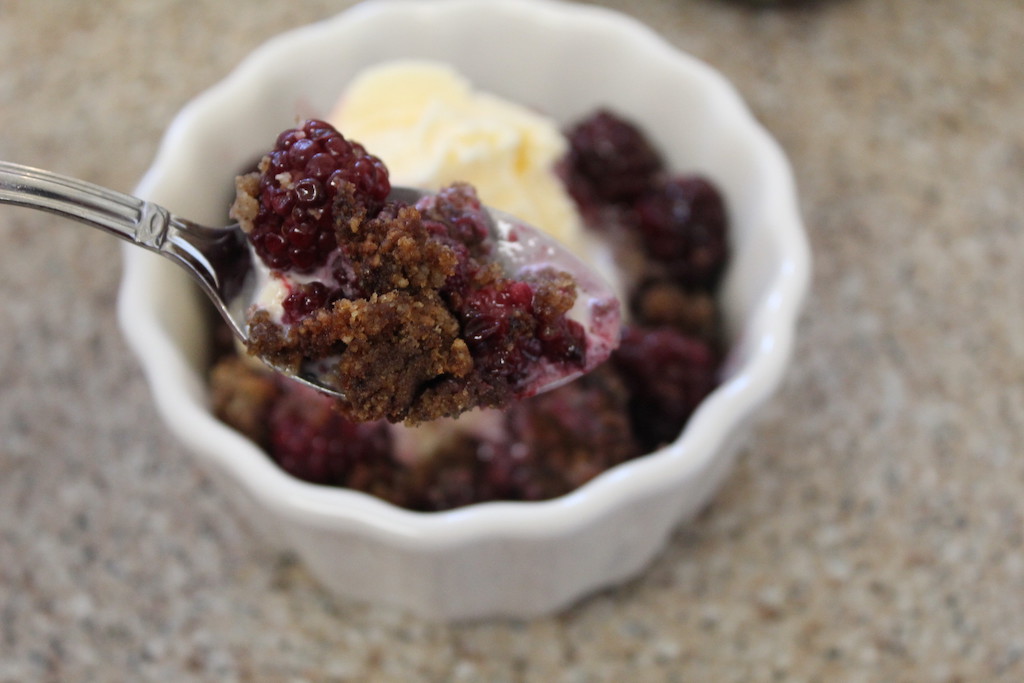 keto berry cobbler on spoon with vanilla ice cream