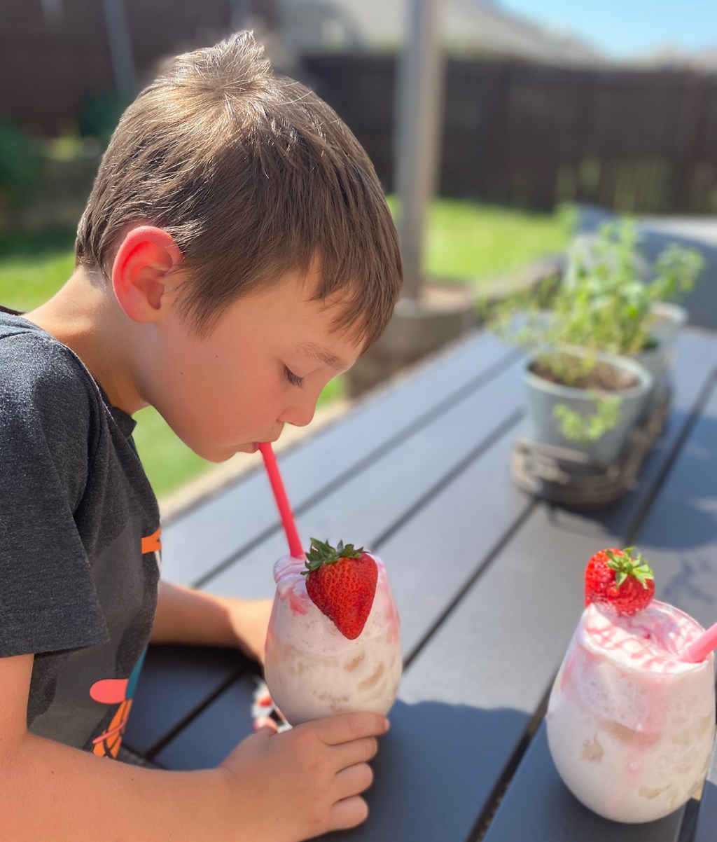 young boy drinking keto whipped strawberry milk