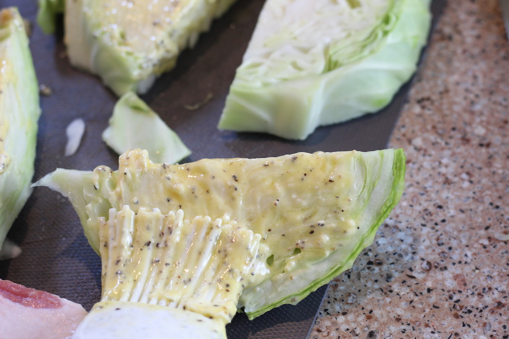 cabbage wedges being slathered in butter 
