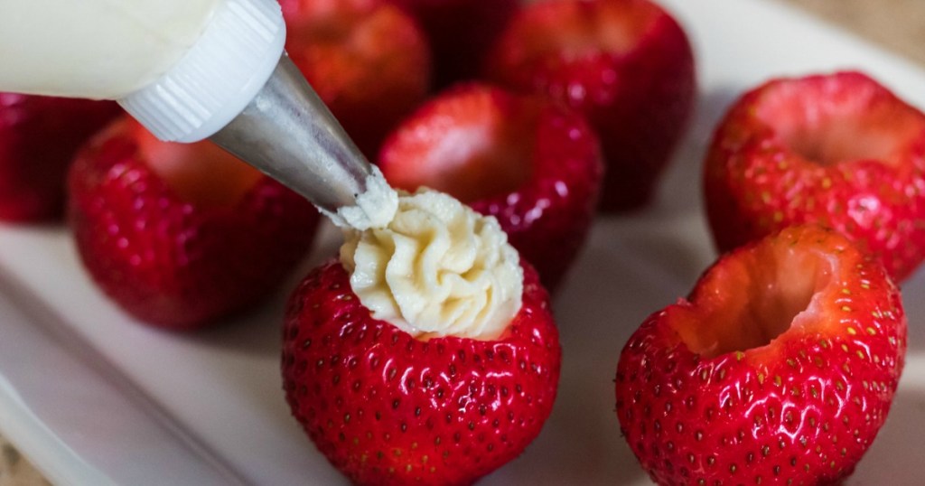 filling fresh strawberries with keto frosting